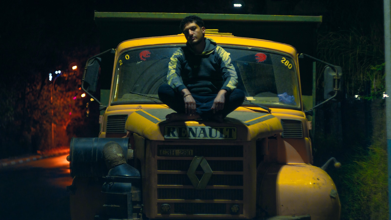 a man sitting on top of a yellow truck with commercial auto insurance